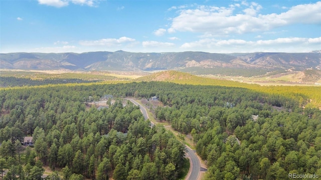 bird's eye view of a heavily wooded area and a mountainous background