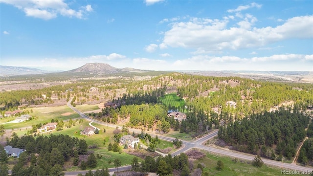 view of property location with a mountain backdrop and a heavily wooded area