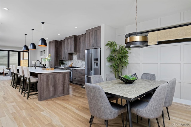 dining space with sink and light hardwood / wood-style flooring