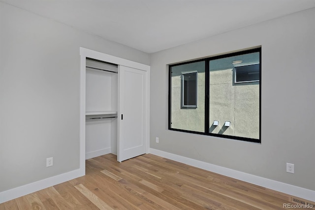 unfurnished bedroom featuring light wood-type flooring and a closet