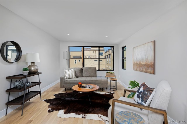 living room with light wood-type flooring and vaulted ceiling