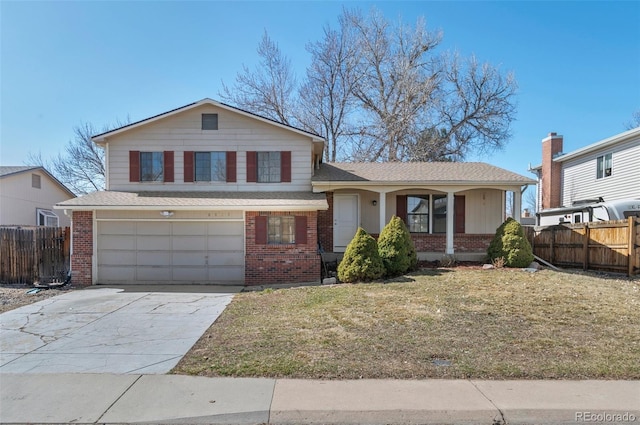 split level home featuring brick siding, fence, a front yard, a garage, and driveway