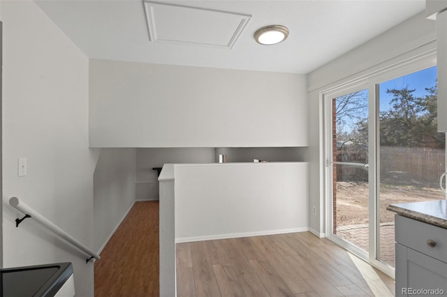 interior space featuring gray cabinetry, light wood-type flooring, and baseboards