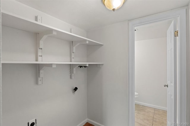 clothes washing area featuring baseboards and laundry area