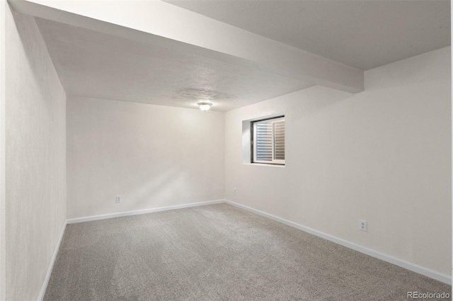 unfurnished room with carpet flooring and baseboards