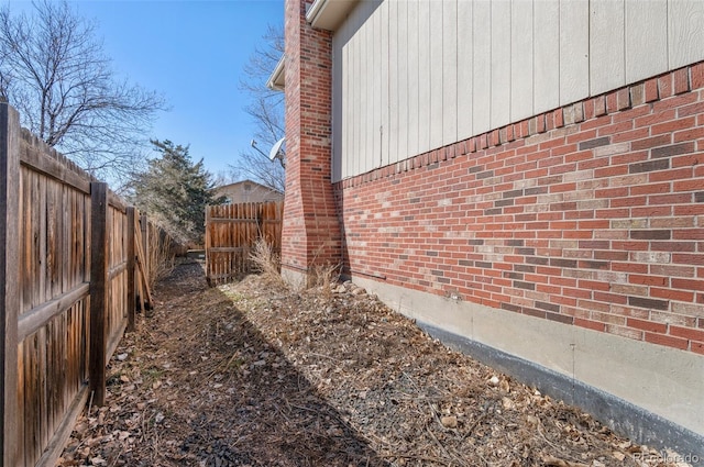 view of property exterior with a fenced backyard and brick siding