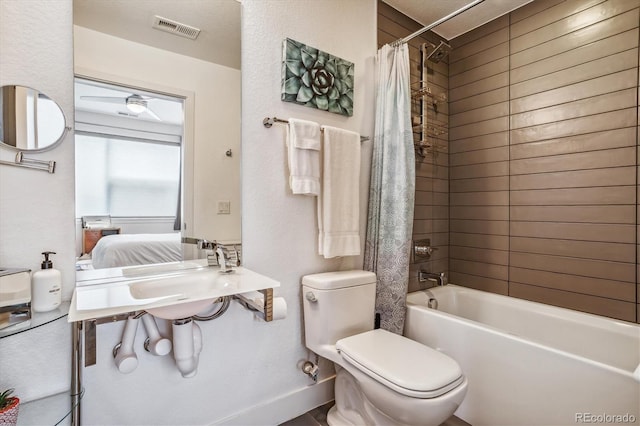 full bathroom featuring ceiling fan, sink, shower / tub combo, and toilet