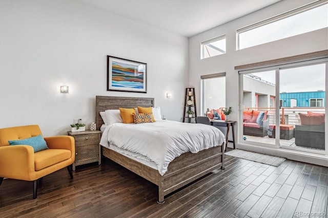 bedroom featuring a towering ceiling and dark wood-type flooring