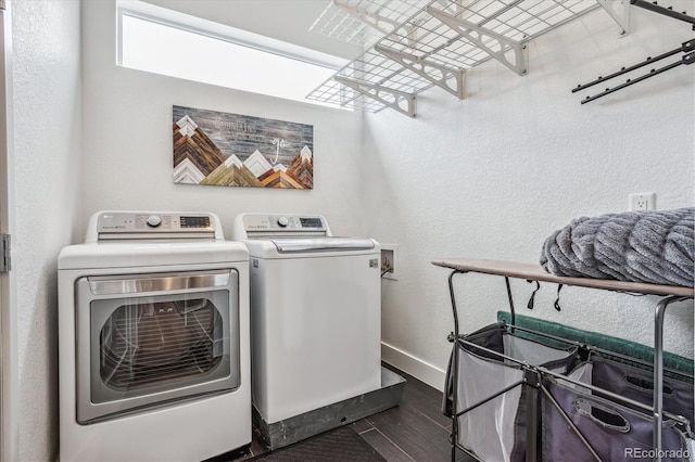 washroom with dark wood-type flooring and washing machine and clothes dryer