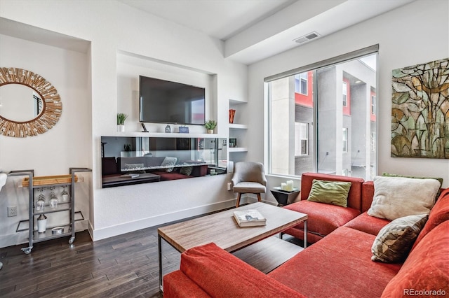 living room with a wealth of natural light and dark hardwood / wood-style floors