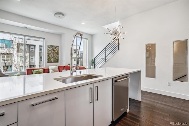 kitchen with dark hardwood / wood-style flooring, dishwasher, and sink