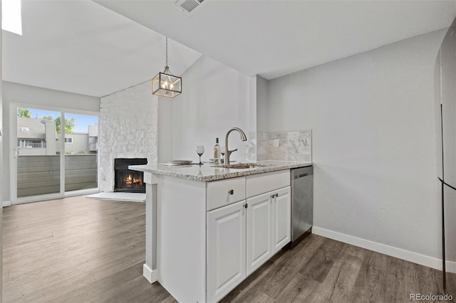 3100 S Federal Blvd Unit 331, Denver, CO 80236 - kitchen with dishwasher, a sink, dark wood-style flooring, a stone fireplace, and baseboards