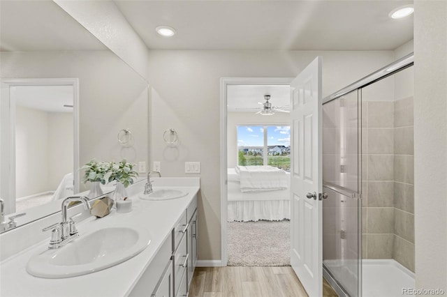 762 N Rome St, Aurora, CO 80018 - ensuite bathroom with wood finished floors, a stall shower, double vanity, a ceiling fan, and baseboards