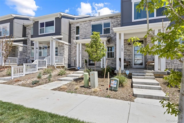 762 N Rome St, Aurora, CO 80018 - view of front of property featuring covered porch, stone siding, and stucco siding