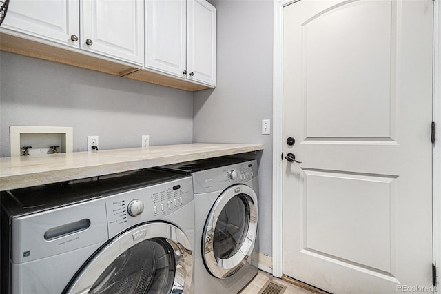 laundry room with cabinets and separate washer and dryer