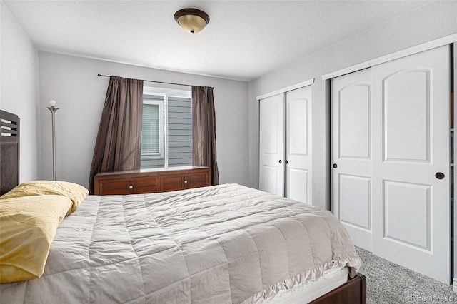 bedroom with carpet and multiple closets