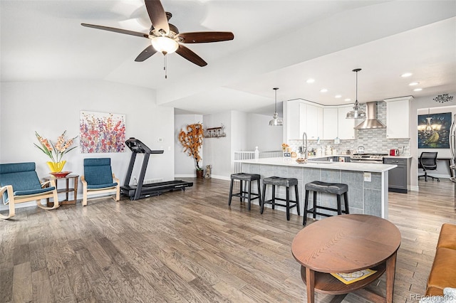 interior space with ceiling fan, light wood-type flooring, sink, and vaulted ceiling