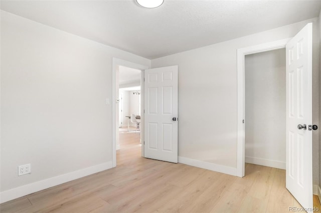 unfurnished bedroom featuring light hardwood / wood-style floors and a closet