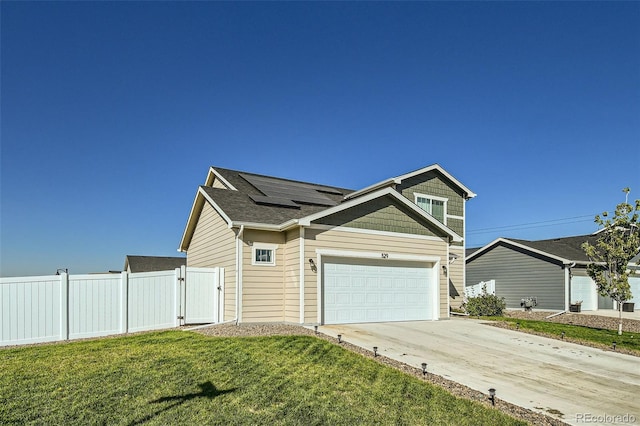 529 Beckwourth, Fort Lupton, CO 80621 - view of front facade with roof mounted solar panels, concrete driveway, a gate, a garage, and roof with shingles