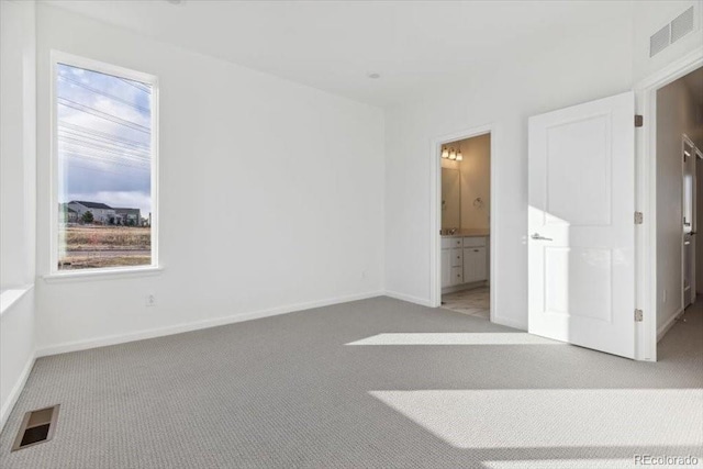 unfurnished room with a wealth of natural light and light colored carpet