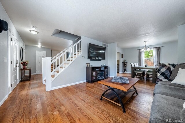 4571 S Memphis St, Aurora, CO 80015 - living room featuring stairs, wood finished floors, baseboards, and a textured ceiling