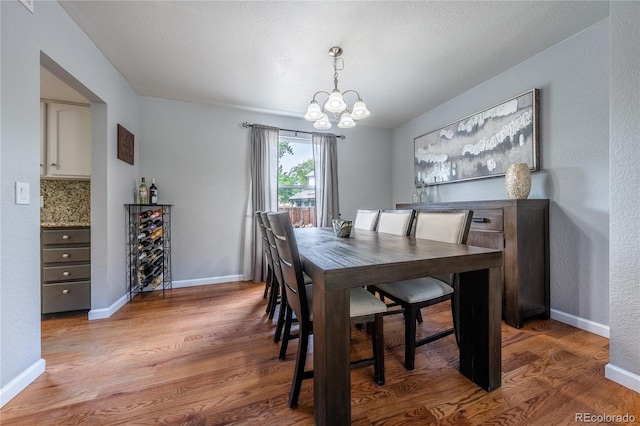 4571 S Memphis St, Aurora, CO 80015 - dining room with a chandelier, wood finished floors, and baseboards