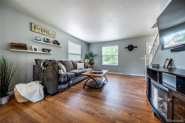 4571 S Memphis St, Aurora, CO 80015 - living area featuring wood finished floors, stairway, a textured ceiling, and baseboards