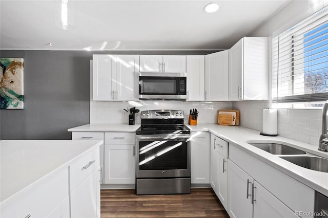 kitchen featuring white cabinetry, stainless steel appliances, sink, and backsplash