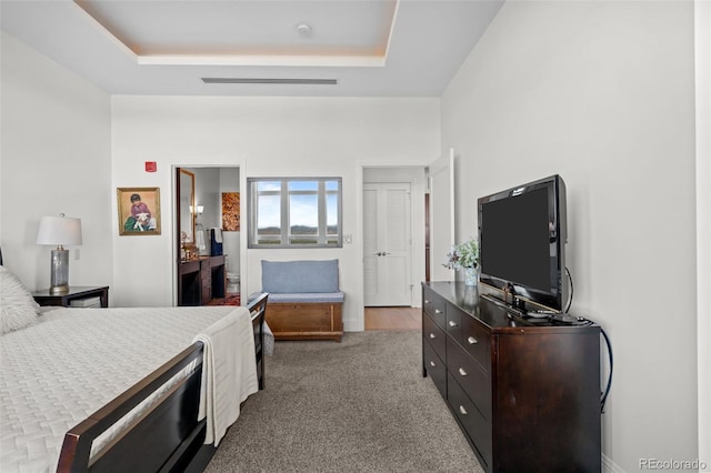 carpeted bedroom with a raised ceiling