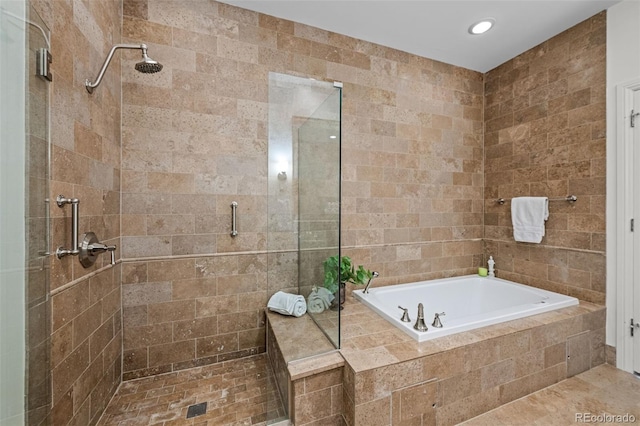 bathroom with tile walls and independent shower and bath