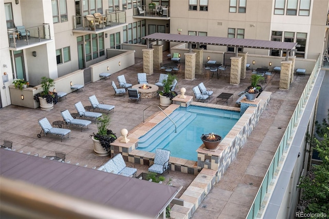 view of swimming pool with a bar, a patio, and a fire pit