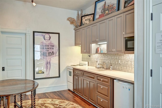 kitchen with vaulted ceiling, white appliances, dark wood-type flooring, sink, and decorative backsplash