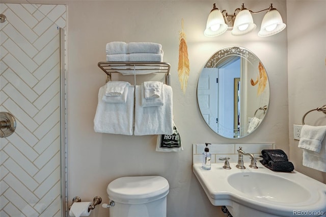 bathroom with a shower, toilet, and sink