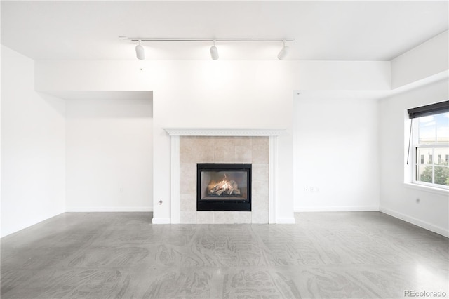 1780 N Washington St Unit 305, Denver, CO 80203 - unfurnished living room with a tiled fireplace, track lighting, and finished concrete floors