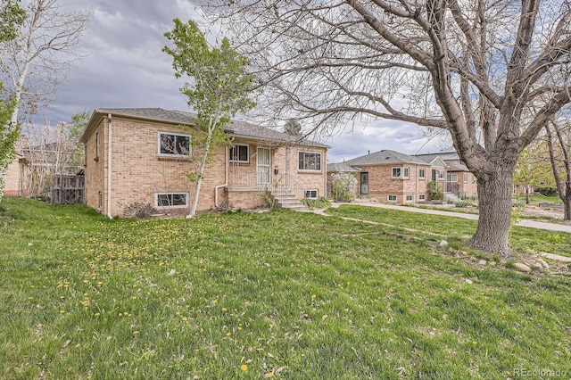 rear view of property with a yard and brick siding