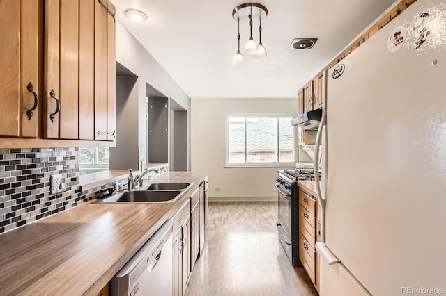 kitchen with plenty of natural light, a sink, white appliances, and tasteful backsplash