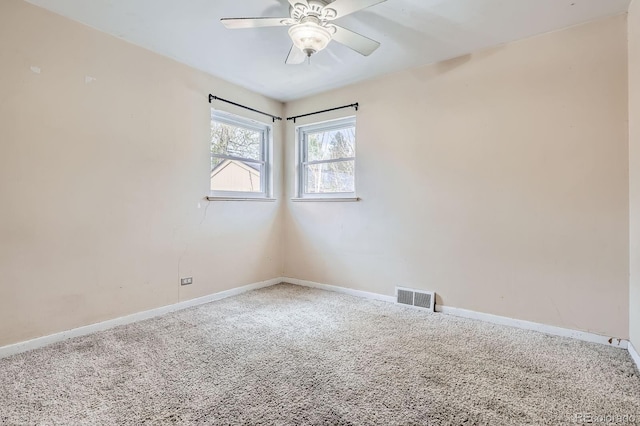 spare room with visible vents, carpet flooring, baseboards, and ceiling fan