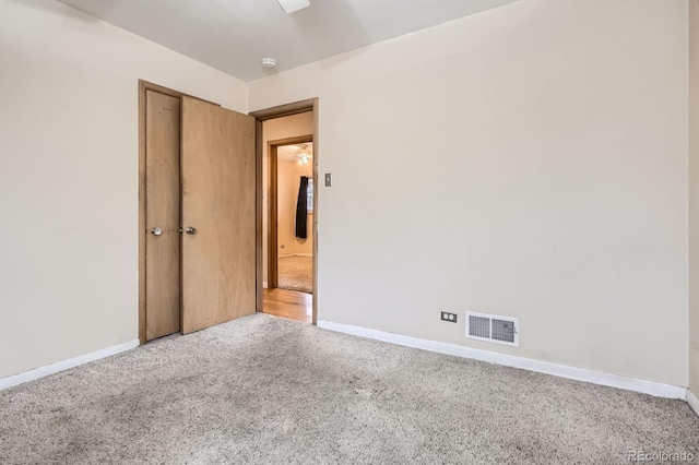 spare room featuring baseboards, carpet, and visible vents