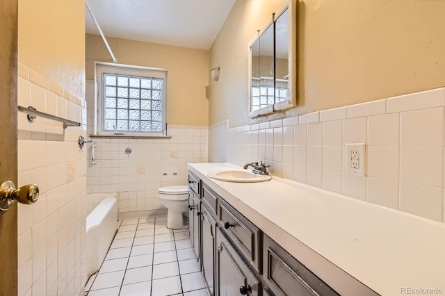 bathroom featuring vanity, wainscoting, toilet, tile walls, and tile patterned floors