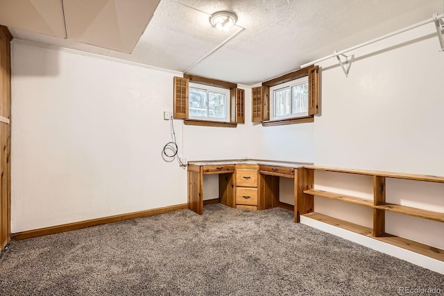 unfurnished office featuring baseboards, carpet, and a textured ceiling