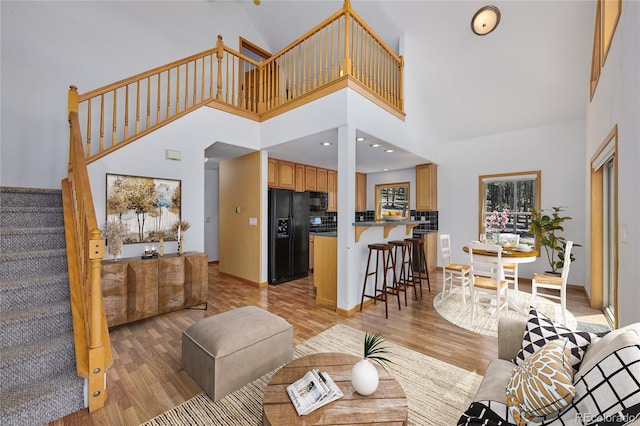 living room featuring a high ceiling and light wood-type flooring