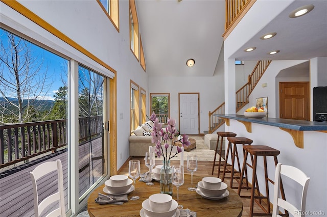 dining room featuring hardwood / wood-style flooring and a high ceiling