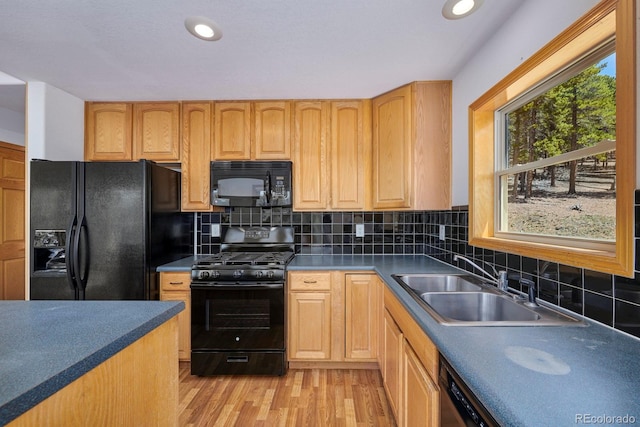 kitchen featuring sink, tasteful backsplash, black appliances, light hardwood / wood-style floors, and light brown cabinets