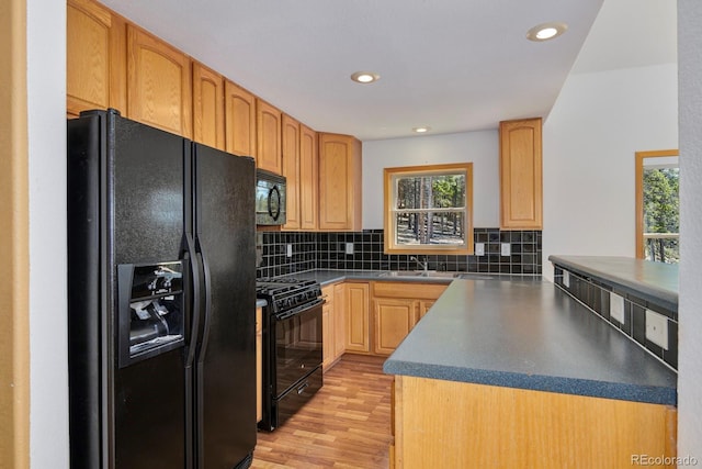 kitchen with sink, decorative backsplash, black appliances, light brown cabinets, and light hardwood / wood-style flooring