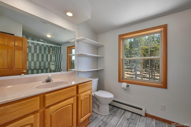 bathroom with vanity, toilet, wood-type flooring, and a baseboard heating unit