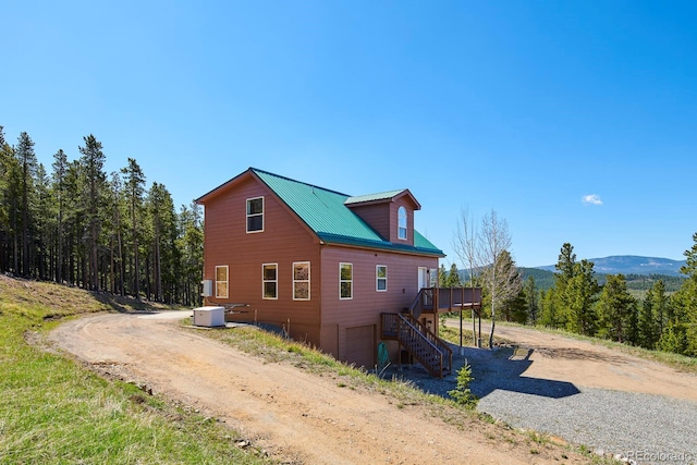 view of home's exterior featuring a garage and a deck with mountain view