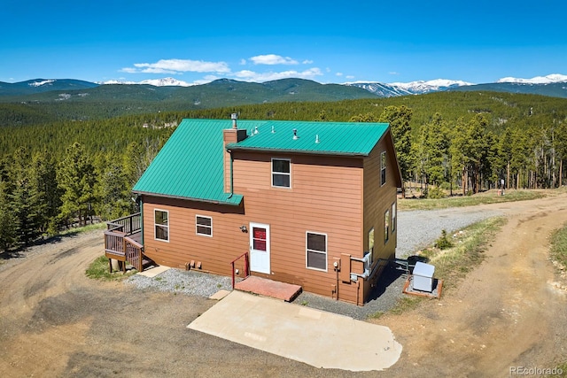 rear view of house featuring a deck with mountain view