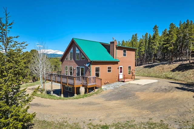 rear view of property featuring a deck with mountain view