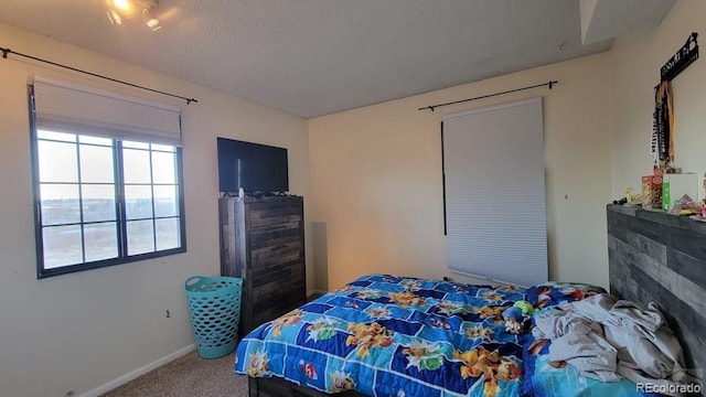 bedroom featuring baseboards, carpet flooring, and a textured ceiling