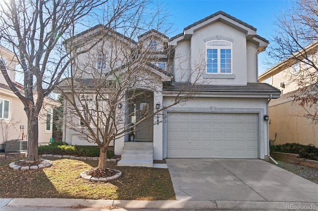 traditional-style home featuring a tile roof, stucco siding, an attached garage, central AC, and driveway